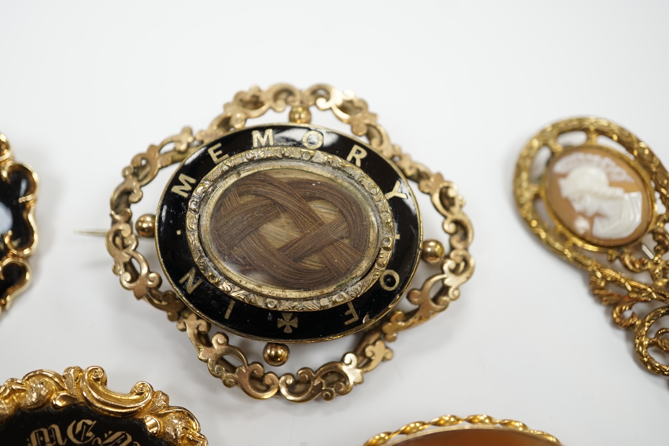 Three assorted Victorian mourning brooches, including two yellow metal, one set with seed pearls and diamond chip and inscribed and dated 1847, 48mm and two cameo shell set brooches.